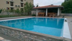 a blue swimming pool with a gazebo at Apartments Suzy in Vantačići