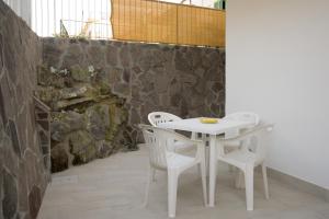 a white table and chairs with a stone wall at Danys home in Ischia Town