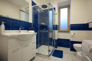 a blue tiled bathroom with a shower and a sink at Danys home in Ischia Town