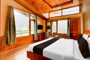 a bedroom with a bed in a room with windows at Hotel O Model Town Road in Manāli +38 photos