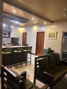 a living room with a bar with chairs and a table at Casa Villa Gracia in Bigaa