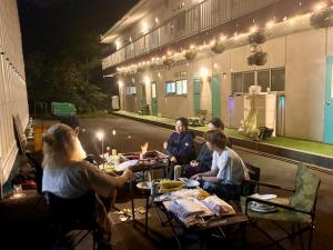 a group of people sitting at a table in front of a building at FUJI Forest House103 in Gotemba