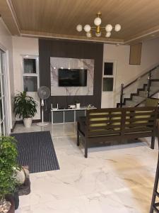 a living room with a couch and a tv and stairs at Casa Villa Gracia in Bigaa
