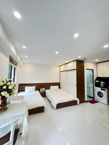 a hotel room with two beds and a kitchen at Fuji Apartment in Hanoi