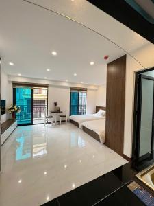 a large bedroom with a bed and a desk at Fuji Apartment in Hanoi