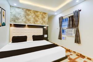 a bedroom with a white bed and a window at Collection O Jagdeo Path Patna in Patna +39 photos