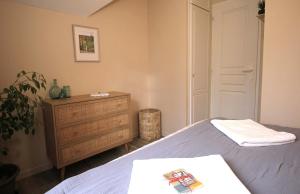 a bedroom with a bed and a wooden dresser at Maison cosy 6 pers - piscine chauffée - nature et lac - Monflanquin in Monflanquin
