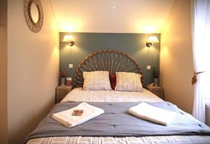 a bedroom with a bed with two towels on it at Maison cosy 6 pers - piscine chauffée - nature et lac - Monflanquin in Monflanquin +37 photos
