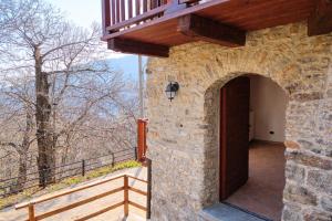 a stone building with a wooden door and a balcony at Maison Champriond in Rif