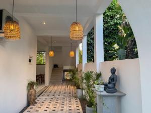 a hallway of a house with potted plants and lights at SIlvas Surf Home in Weligama