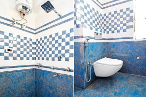 a bathroom with blue and white tiled walls and a toilet at Super Collection O Raja Bazar Bailey Road in Patna