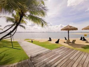 a beach with a group of chairs and an umbrella at Best Hotel in Johor Bahru