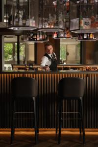 a man standing behind a bar with two chairs at Das Paradies in Laces