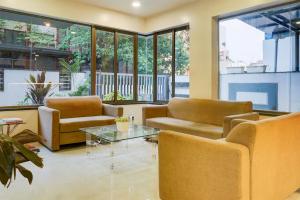 a lobby with couches and a table and windows at Super Townhouse Oak Viman Nagar Formerly Kuber Inn in Pune
