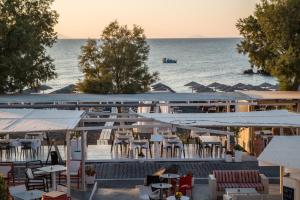 un ristorante con tavoli e sedie e l'oceano di Beach Boutique Hotel a Kamari