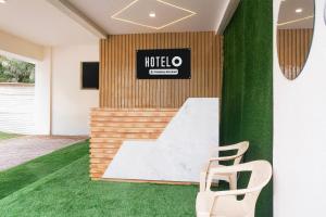 a white chair sits in a room with green grass at Super Hotel O Laxman Nagar Baner in Pune