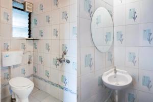 a bathroom with a toilet and a sink at Super Hotel O Laxman Nagar Baner in Pune
