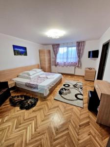 a bedroom with a bed and a wooden floor at Popasul Ursului Zărnești in Zărneşti