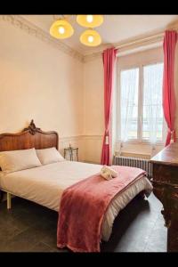 a bedroom with a bed with a teddy bear on a blanket at Appart de charme, centre Vichy, Thermes in Vichy