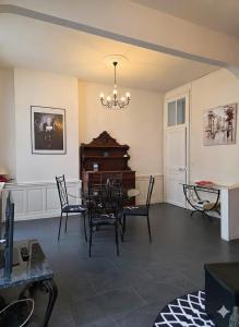 a living room with a table and chairs and a chandelier at Appart de charme, centre Vichy, Thermes in Vichy +7 photos