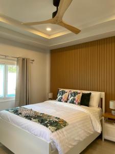 a bedroom with a large bed with a ceiling fan at Samui Serenity 63 Pool Villa in Choeng Mon Beach