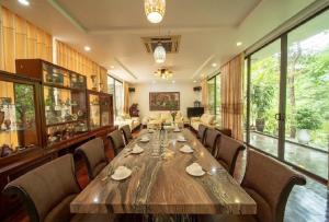 a dining room with a large wooden table and chairs at Villa Owner tại khu nghỉ dưỡng sinh thái Đại Lải Resort in Ngọc Quang