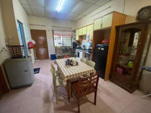 a kitchen with a table and chairs in a room at Homestay 3U MU5L1M Only in Cukai