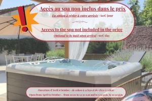 a spa tub in a yard with an umbrella at Gîte de charme Beaujoyeulx in Molineuf