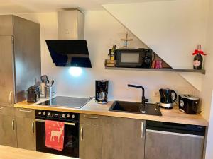 a kitchen with a sink and a microwave at Appartement Bergtraum - by myNests in Gröbming