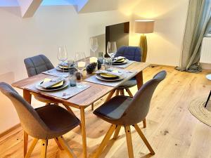 a dining room table with chairs and wine glasses at Appartement Bergtraum - by myNests in Gröbming