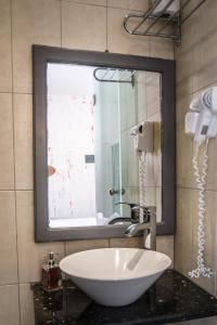 uma casa de banho com um espelho grande e um lavatório em Beach Boutique Hotel em Kamari
