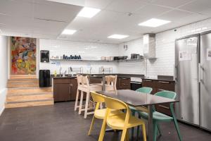 a kitchen with a table and chairs and a refrigerator at City Hostel in Stockholm