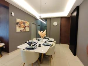 a dining room with a white table and chairs at Ipoh Meru 3 Bedroom Suites by IWH Suites in Ipoh