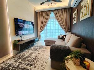 a living room with a couch and a flat screen tv at Ipoh Meru 3 Bedroom Suites by IWH Suites in Ipoh