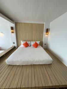 a bedroom with a white bed with two orange pillows at Bari Lamai Resort in Ban Phe +23 photos