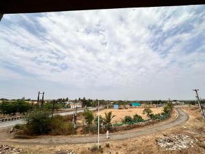 a road in a field with a cloudy sky at Hotel Jatra in Sillod