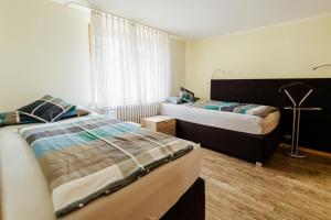 a bedroom with two beds and a window at Ferienwohnung Schwarzwaldsteig in Bad Peterstal-Griesbach