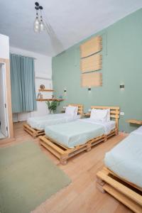 two beds in a room with blue walls and wooden floors at Rhala Hostel Egypt in Cairo +75 photos