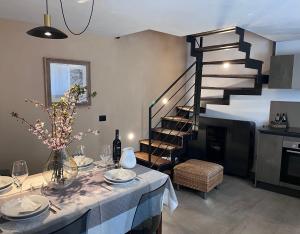 a dining room with a table and a spiral staircase at Little Wild House in Saint Vincent
