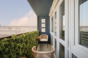a balcony with two chairs and a view of a building at Sunset Apartment - 7th Floor Double Tree in Brighton & Hove