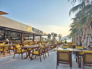 a restaurant with wooden tables and yellow chairs at Waikiki Apartments in Tivat