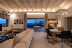 ein Wohnzimmer mit Sofa und ein Esszimmer in der Unterkunft Vivere Suites in Nafplio
