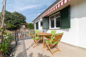 a patio with a table and chairs on a balcony at Nikola's spacious apartment in Božava