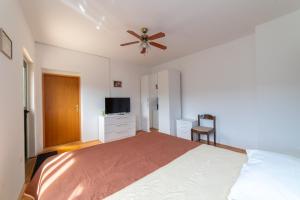 a bedroom with a bed and a ceiling fan at Nikola's spacious apartment in Božava