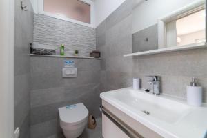 a bathroom with a white sink and a toilet at Nikola's spacious apartment in Božava +7 photos