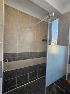 a shower with a glass door in a bathroom at La Roseraie in Le Mans