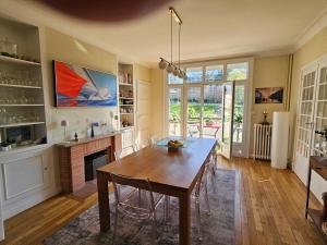 a dining room with a table and a fireplace at La Roseraie in Le Mans +9 photos