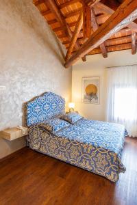 ein Schlafzimmer mit einem Bett mit blauer Bettdecke und einem Fenster in der Unterkunft Hotel Villa Braida in Mogliano Veneto + 73 Fotos