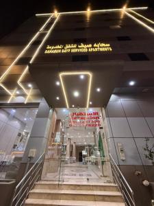 a staircase in a building with a sign on the ceiling at سحابة صيف للشقق المخدومه 1 - حي النزهه - in Abha