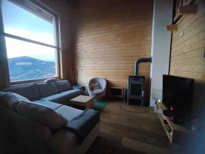 a living room with a couch and a large window at Bergliebe Klippitztörl in Klippitztorl